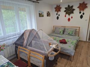 a bedroom with two beds and a baby crib at Agroturystyka Przy Rajskim Sadzie in Nowy Berezów