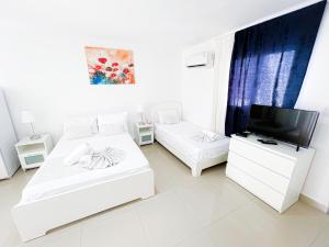 蓬塔卡纳CARIBBEAN Paradise TROPICAL HOTEL with VIEW Los Corales WiFi Beach CLUB & SPA的白色客房 - 带两张床和平面电视