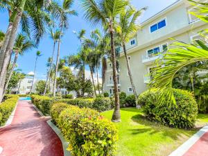 蓬塔卡纳CARIBBEAN Paradise TROPICAL HOTEL with VIEW Los Corales WiFi Beach CLUB & SPA的棕榈树建筑前的走道 更多28张照片