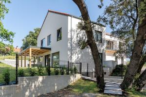 a white house with a fence and a tree at BAO 3 Apartamento con terraza in Somo
