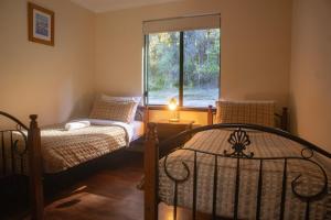 a bedroom with two beds and a window at #4 Walpole Wilderness Resort chalet - Spa & Forest! in Walpole