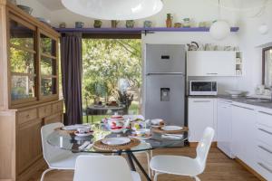 cocina con mesa de cristal y electrodomésticos blancos en Villa Talia 4 by Massimo Villas, en Cefalú 30 fotos más