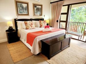 a bedroom with a large bed and a balcony at Villa T3 - Selborne Golf Estate in Pennington