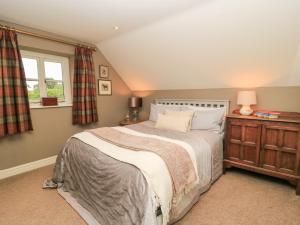 a bedroom with a bed and a window at Pudding Hill Barn Cottage in Cirencester