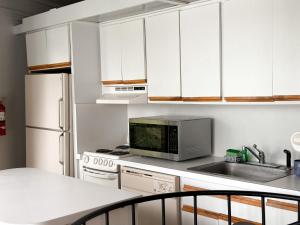 a kitchen with white cabinets and a sink and a microwave at Treetop-forest Flatsunit22 -four Seasons in Four Seasons