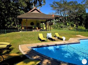a swimming pool with chairs and a gazebo at Villa T3 - Selborne Golf Estate in Pennington