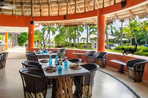 a restaurant with tables and chairs and a view of the ocean at Alamar Vallarta vta in Cruz de Huanacaxtle