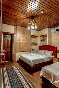 a bedroom with two beds and a wooden ceiling at sermest house in Sanlıurfa