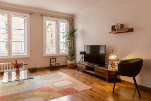 a living room with a tv and a glass table at Authentique 2 chambres, Hyper centre, french Corner in Troyes