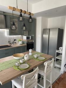 a kitchen with a wooden table with white chairs at Il Respiro del Mare in Levanto