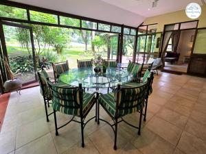 Un comedor con una mesa de cristal y sillas. en Villa A13 - Selborne Golf Estate, en Pennington