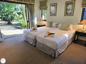 Dos camas en una habitación de hotel con flores en ellas. en Villa A13 - Selborne Golf Estate, en Pennington
