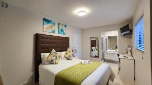 a bedroom with a large bed and a bathroom at Sunset Events And Accommodation-East London in East London