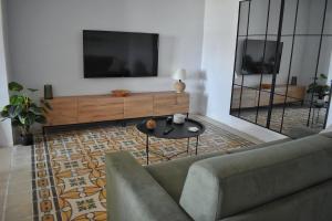 a living room with a couch and a tv at 4 Borgo Vilhena - Home in Floriana in Il-Furjana