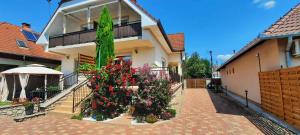 a house with a bunch of flowers in a courtyard at Holiday home in Keszthely - Balaton 54377 in Keszthely