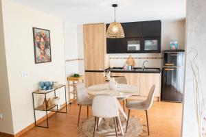 a kitchen and dining room with a table and chairs at Apartamentos Eras Centro in Malpartida de Plasencia
