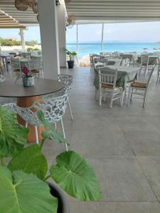 a restaurant with tables and chairs and the ocean at Hotel Alexandra in Skala
