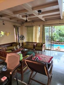 纳加奥恩veeras Homestay的带沙发和椅子的客厅以及游泳池