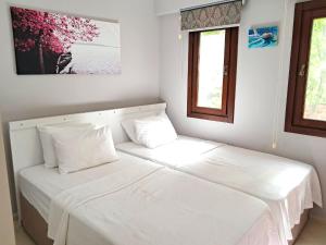 1 cama blanca con 2 almohadas en una habitación en The Villages, C3 Suite Apart , Havuz, Barbeku, Balkon Teras, en Ölüdeniz 24 fotos más