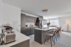 a kitchen with a counter and some chairs in it at Magnifique Rooftop a Antibes 4 chambres in Antibes