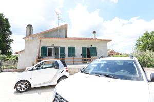 a white car parked in front of a house at Guest House Rossetto & Caffè in Colle di Fuori