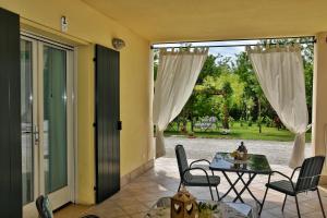 un patio con tavolo, sedie e porta in vetro di BB Il Grande Salice Bike Friends a Ponti Sul Mincio