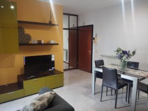 a living room with a table and chairs and a television at Cozy House in Civitavecchia
