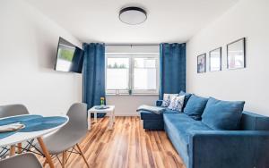 salon z niebieską kanapą i stołem w obiekcie Apartamenty Dostoja we Władysławowie