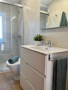 a bathroom with a sink and a toilet and a shower at Apartment with a pool near the beach in Riumar +17 photos