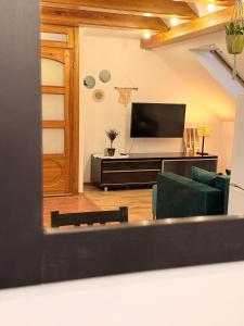 a living room with a couch and a television at Widokowo - Apartament z tarasem i ogródkiem in Tuchom