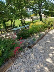 a park with a bench and some flowers and trees at Domaine la cheneraie in Mirabel