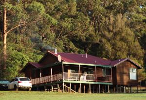 a house with a porch and a car parked in front at #4 Walpole Wilderness Resort chalet - Spa & Forest! in Walpole