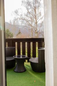 a porch with chairs and a table on a balcony at ADB - parking, balcon et centre ville in Albertville +8 photos