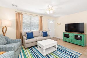 Una sala de estar con un sofá y un televisor. en Bowline Bungalow, en Tybee Island