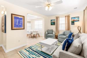 Una sala de estar con un sofá y sillas y una mesa. en Bowline Bungalow, en Tybee Island