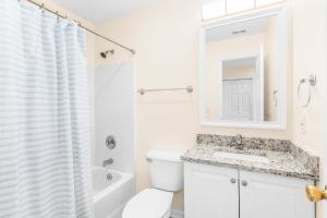 Un baño blanco con inodoro y lavabo. en Bowline Bungalow, en Tybee Island 39 fotos más