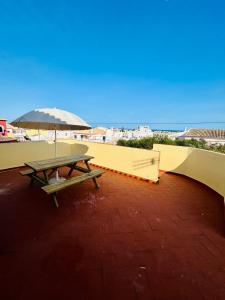 a picnic table with an umbrella on top of a roof at Travellers Guesthouse in Lagos