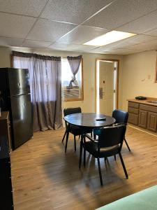 a room with a table and chairs and a refrigerator at Homestead Inn Extended Stay - 3 nights min in Wolf Point