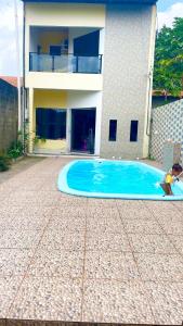 a house with a swimming pool in front of a house at Linda Casa a 25min da COP30 in Marituba