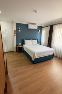 Un dormitorio con una cama grande y una pared azul. en Red Green, en Izmir