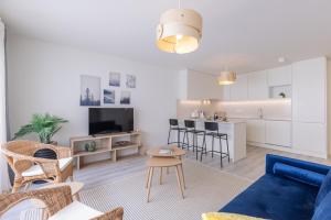 a living room with a blue couch and a kitchen at Peniche Hideout in Peniche