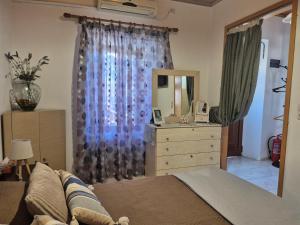 a bedroom with a bed and a dresser with a mirror at Afroditi's 1 in Eresos