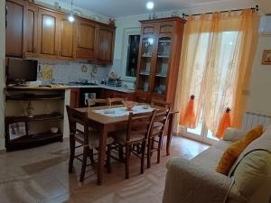 a kitchen with a table and chairs and a couch at Casa Teresa in Gioiosa Marea