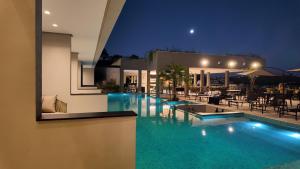 a swimming pool in a villa at night at Collegare Hotel in Capitólio