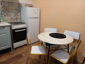 Una cocina con mesa y sillas y un refrigerador. en Casa da Nonô, en Coímbra 17 fotos más