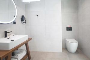 a white bathroom with a sink and a toilet at Sunset View Paleros - Boutique Suites in Paleros +11 photos