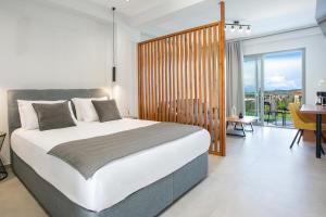 a bedroom with a large bed and a dining room at Sunset View Paleros - Boutique Suites in Paleros