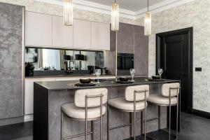 Luxury Old Town Apartment With Private Jacuzzi في إدنبرة: مطبخ مع بار مع الكراسي وطاولة