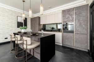 a kitchen with a black island with bar stools at Luxury City Centre Retreat - Lux Spa Bath - Romantic in Edinburgh