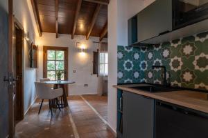 a kitchen with a sink and a table at Málaga Sierra de las Nieves by Real Spain Hotels Adults Recommended in Casarabonela
